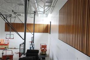 回收的看台木材被安装在新的体育馆墙上 